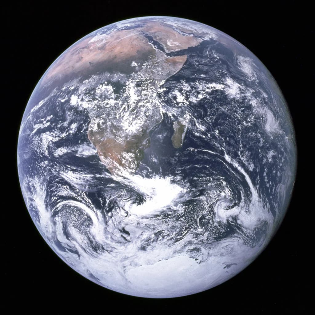 Earth seen from deep space, oceans and clouds glowing.